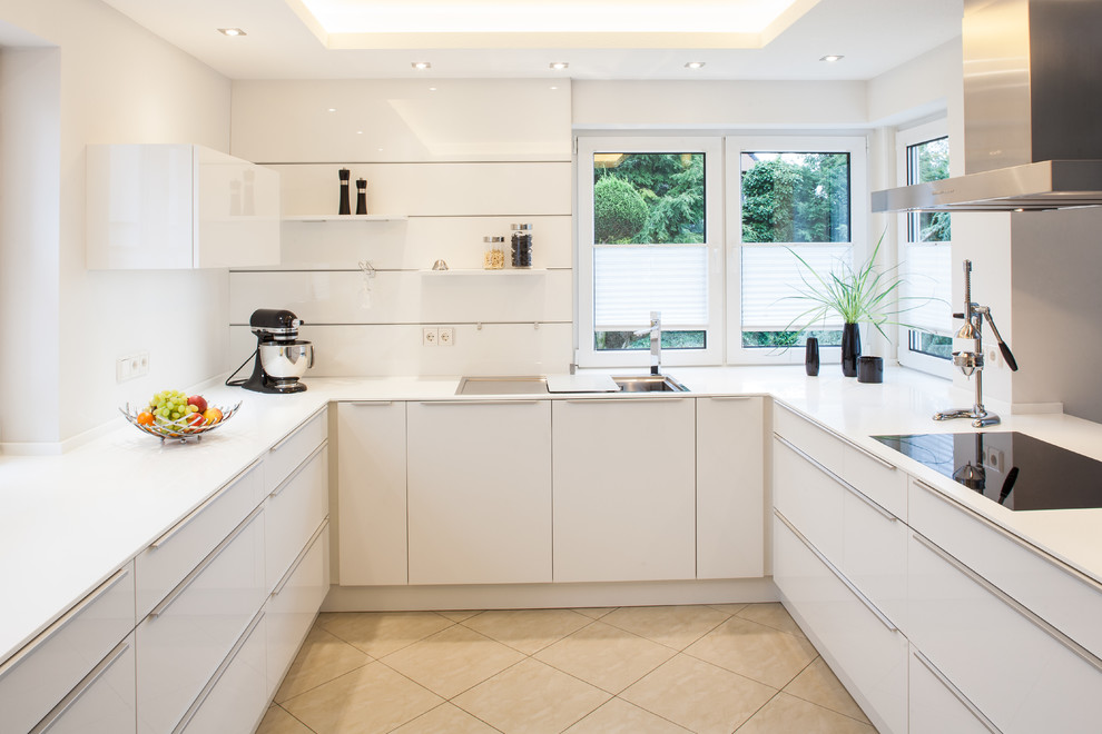 Photo of a small contemporary u-shaped separate kitchen in Bremen with flat-panel cabinets, white cabinets, a drop-in sink, no island, granite benchtops, white splashback, window splashback, stainless steel appliances, cement tiles and beige floor.