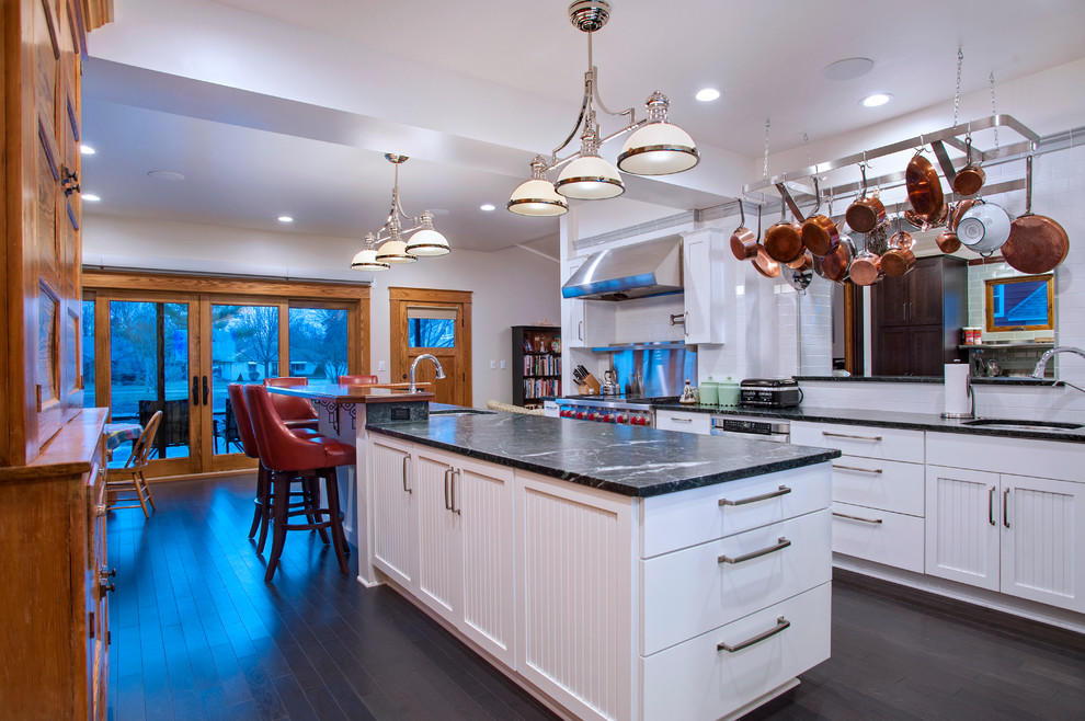 Kitchen - transitional dark wood floor kitchen idea with a single-bowl sink, recessed-panel cabinets, white cabinets, soapstone countertops, white backsplash, subway tile backsplash, stainless steel appliances and an island