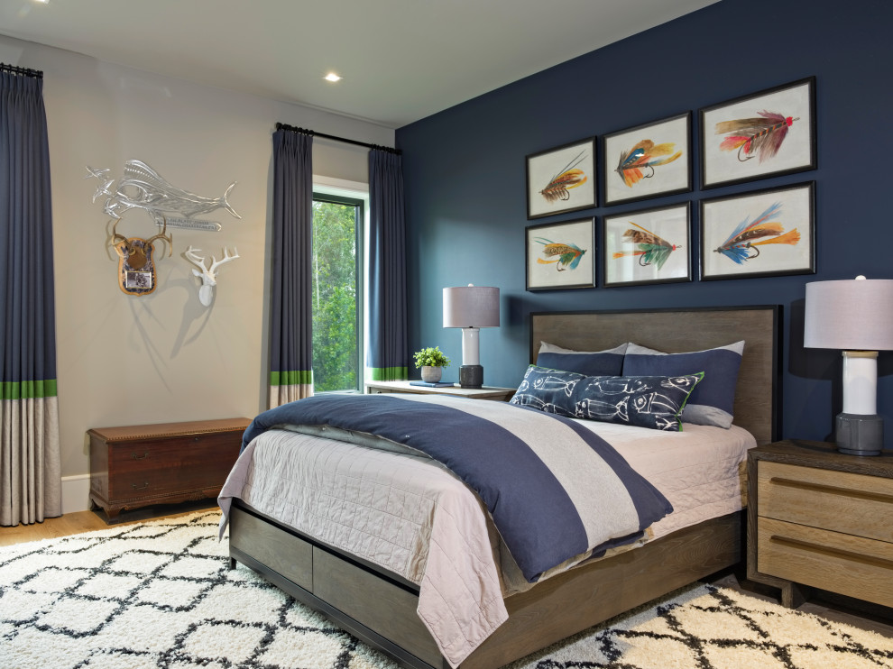 This is an example of a large traditional guest bedroom in Miami with blue walls, light hardwood flooring and brown floors.