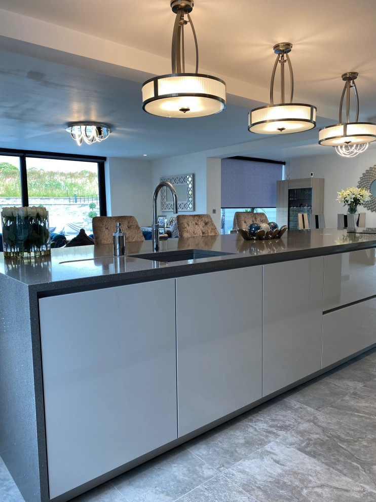 Design ideas for a large contemporary galley open plan kitchen in Manchester with an undermount sink, flat-panel cabinets, grey cabinets, quartzite benchtops, coloured appliances, porcelain floors, with island, grey floor and grey benchtop.