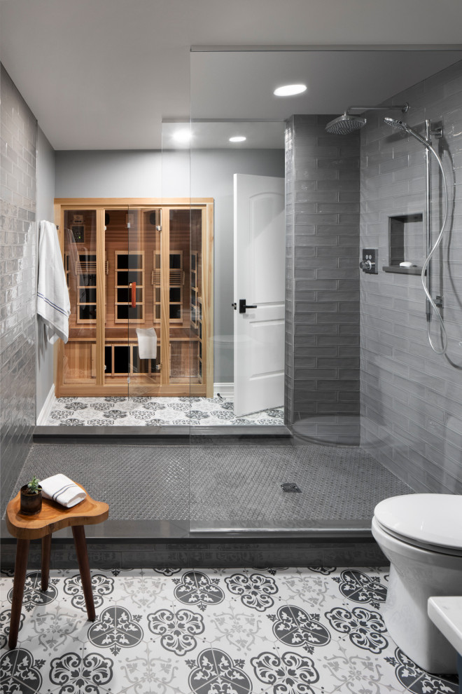 This is an example of a transitional bathroom in Milwaukee with an open shower, gray tile, ceramic tile, grey walls, ceramic floors, with a sauna, grey floor and a hinged shower door.