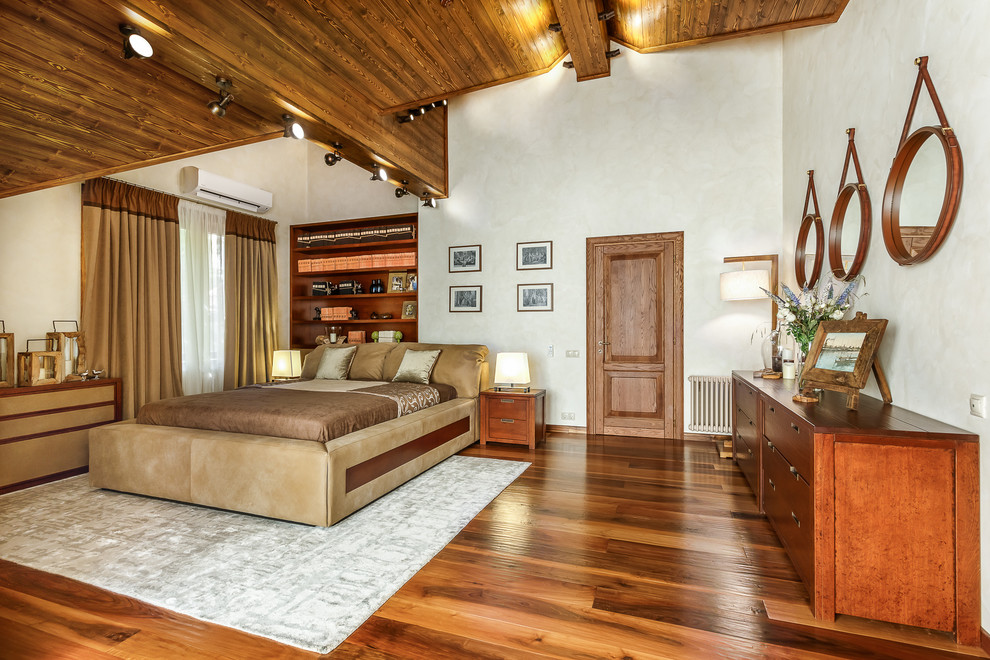 Large country master bedroom in Moscow with beige walls, medium hardwood floors and brown floor.