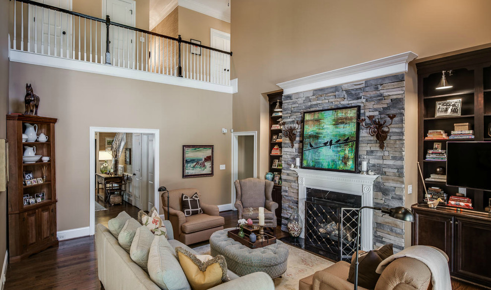 Photo of a mid-sized transitional open concept living room in Charlotte with beige walls, dark hardwood floors, a standard fireplace, a stone fireplace surround and a built-in media wall.