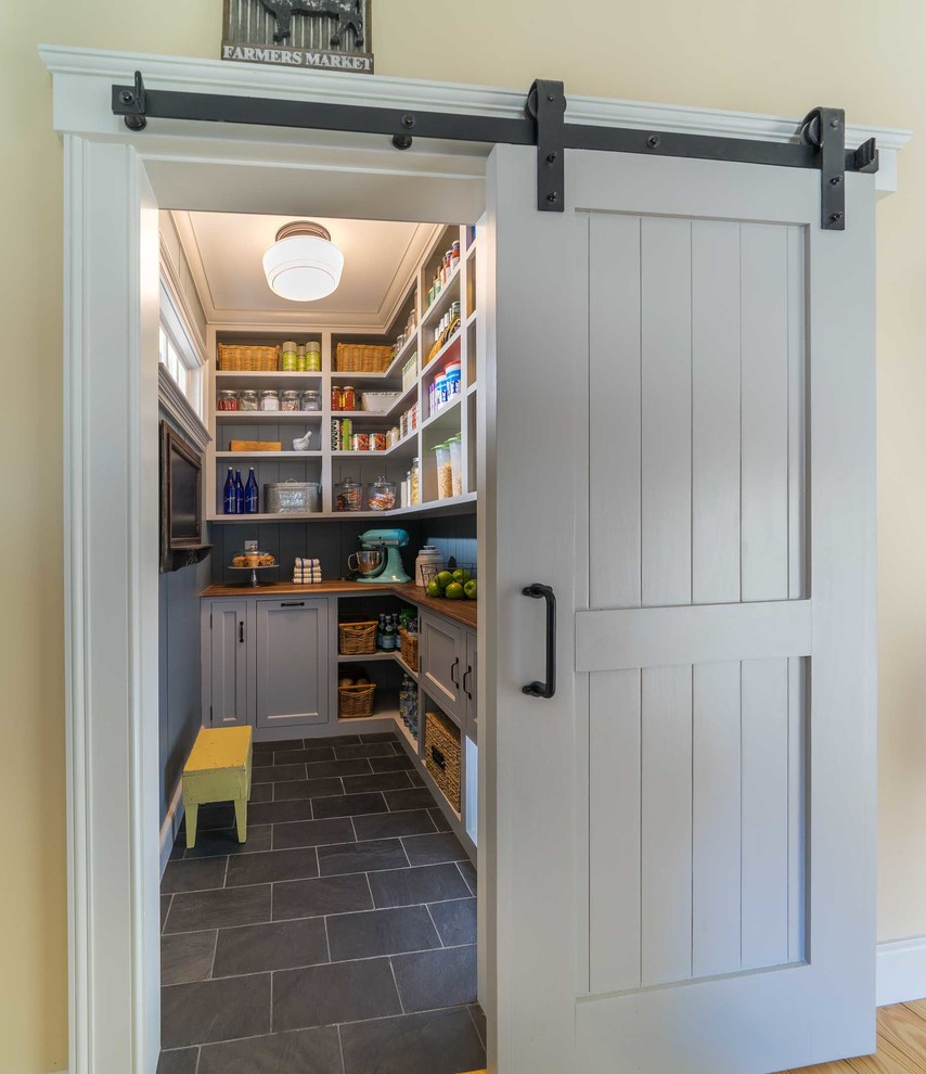 Design ideas for a mid-sized country kitchen pantry in Boston with recessed-panel cabinets, grey cabinets, wood benchtops, ceramic floors and grey floor.