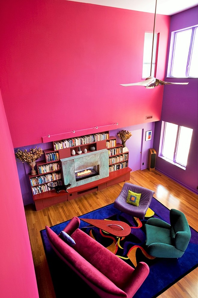 Large eclectic open concept living room in New York with pink walls, medium hardwood floors and a ribbon fireplace.