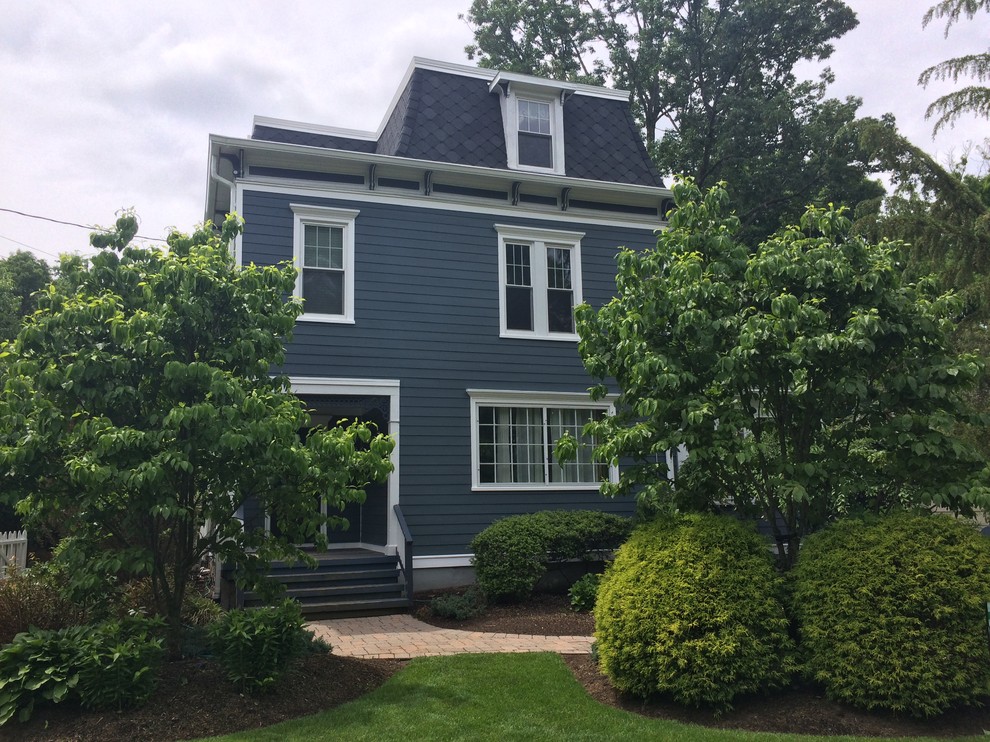 This is an example of a mid-sized traditional three-storey blue exterior in New York with concrete fiberboard siding and a hip roof.