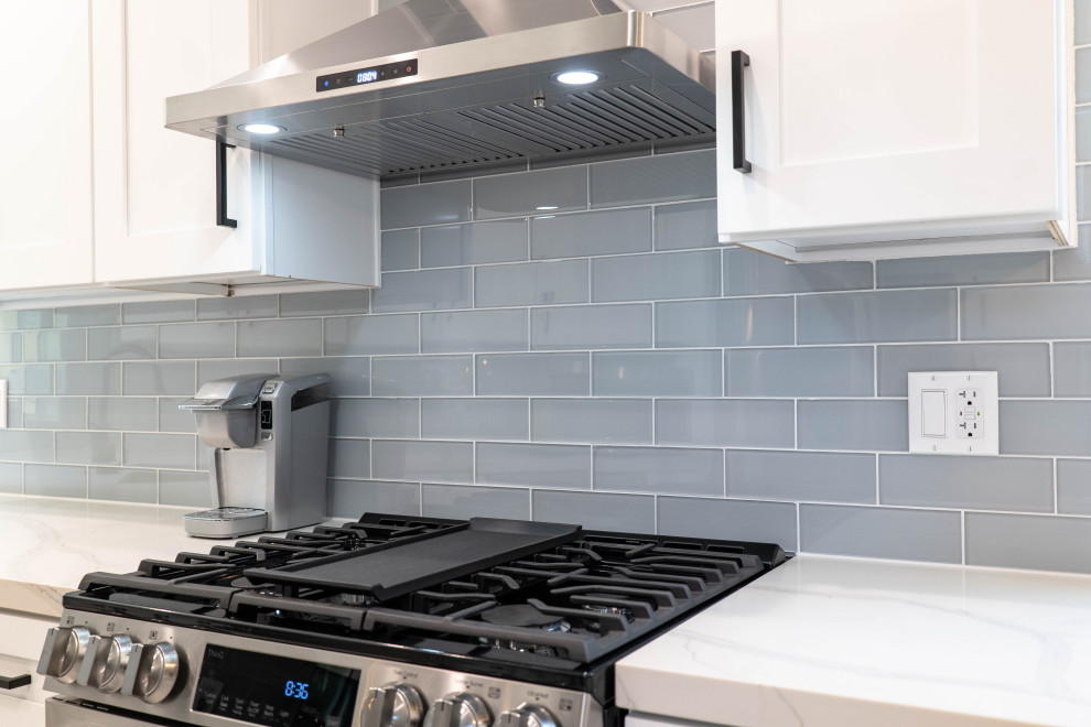 Photo of a medium sized modern u-shaped enclosed kitchen in Los Angeles with a built-in sink, raised-panel cabinets, white cabinets, granite worktops, blue splashback, metro tiled splashback, stainless steel appliances, marble flooring, no island, white floors and white worktops.