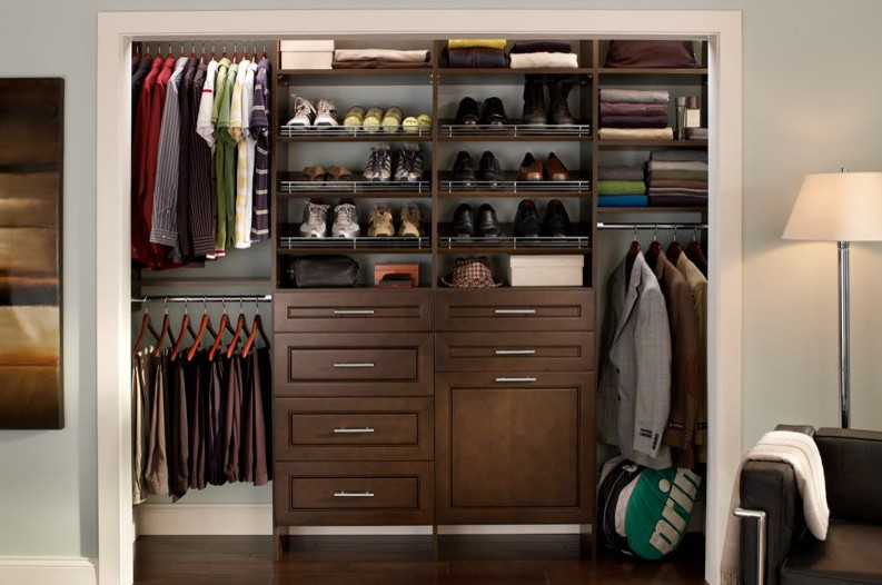 Inspiration for a small contemporary men's built-in wardrobe in Toronto with raised-panel cabinets, dark wood cabinets, dark hardwood floors and brown floor.