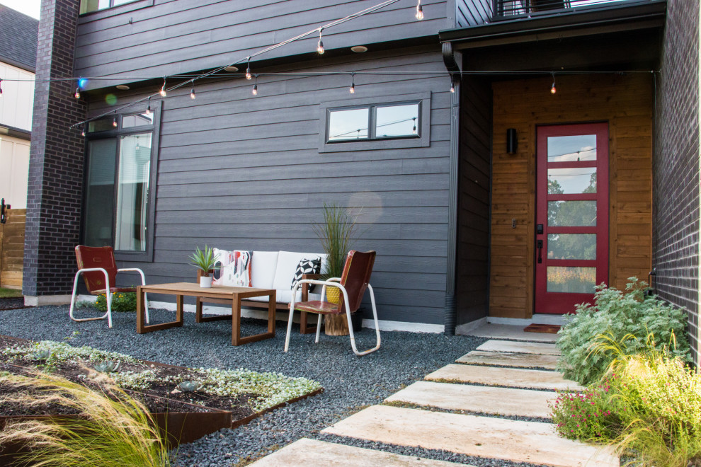 Immagine di un giardino minimalista esposto in pieno sole di medie dimensioni e davanti casa in primavera con ghiaia e recinzione in legno