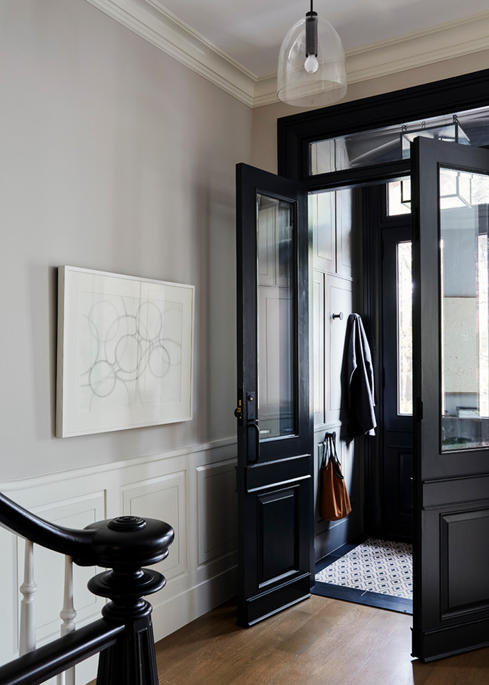 Inspiration for a transitional vestibule in New York with grey walls, medium hardwood floors, a double front door and a black front door.