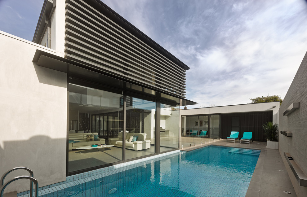 Large contemporary two-storey stucco grey exterior in Melbourne with a flat roof.