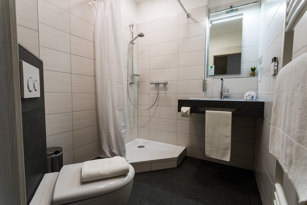 This is an example of a contemporary 3/4 bathroom in Nuremberg with a curbless shower, white tile, ceramic tile, white walls and ceramic floors.