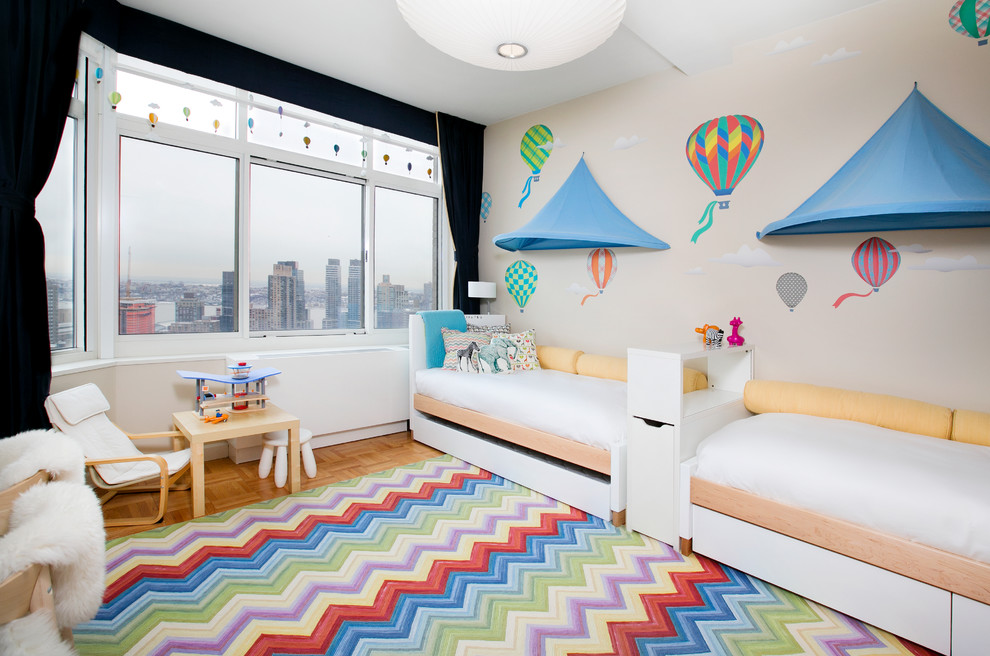 Photo of a mid-sized contemporary gender-neutral kids' bedroom for kids 4-10 years old in New York with beige walls and light hardwood floors.