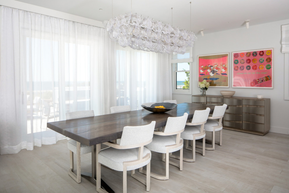 This is an example of a coastal enclosed dining room in New York with grey walls, medium hardwood flooring and brown floors.
