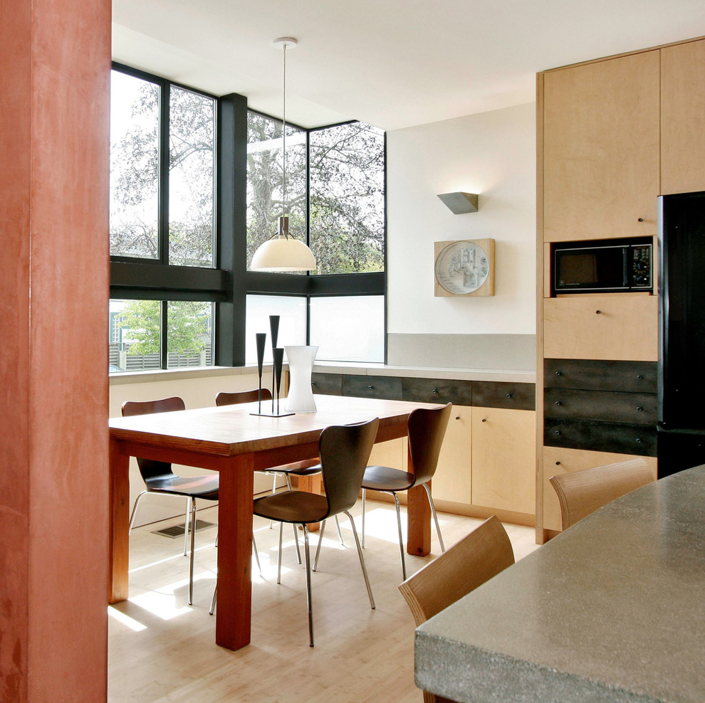 Photo of a modern eat-in kitchen in San Francisco with flat-panel cabinets, light wood cabinets and concrete benchtops.