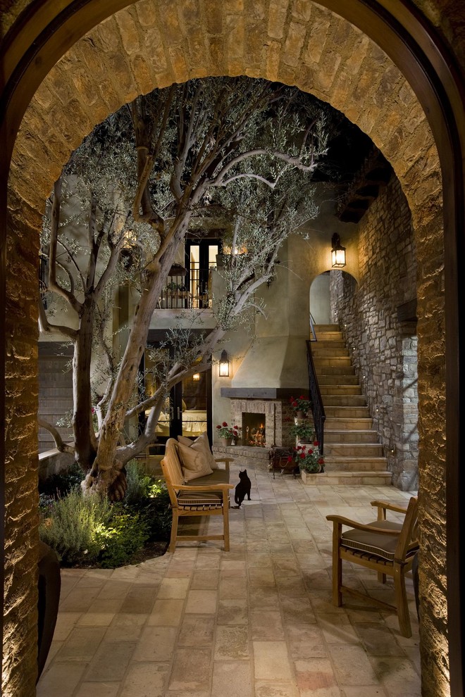 This is an example of a mediterranean courtyard patio in San Diego with a fire feature.