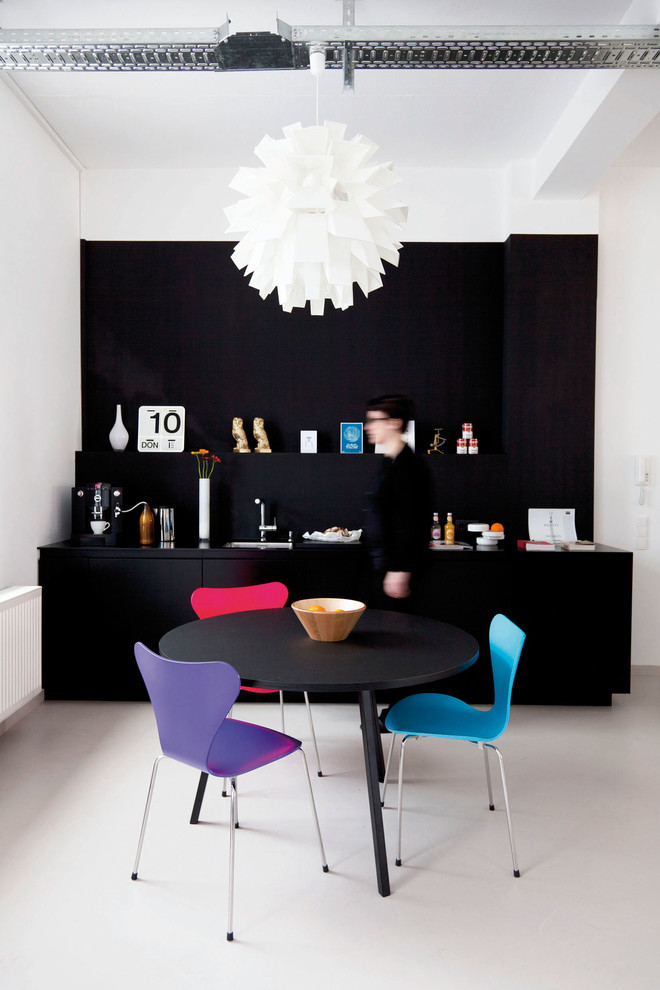 Small contemporary single-wall eat-in kitchen in Frankfurt with flat-panel cabinets, black cabinets, an undermount sink, black splashback, panelled appliances and no island.
