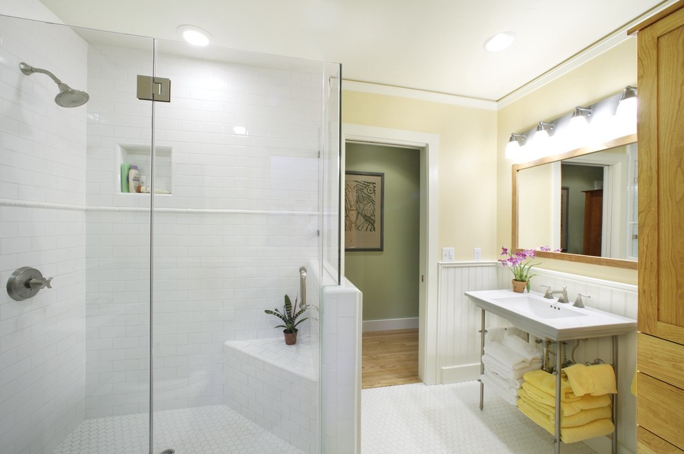 Photo of a mid-sized country master bathroom in Sacramento with furniture-like cabinets, white tile, yellow walls, light wood cabinets, a corner shower, a two-piece toilet, subway tile, ceramic floors, a pedestal sink and solid surface benchtops.