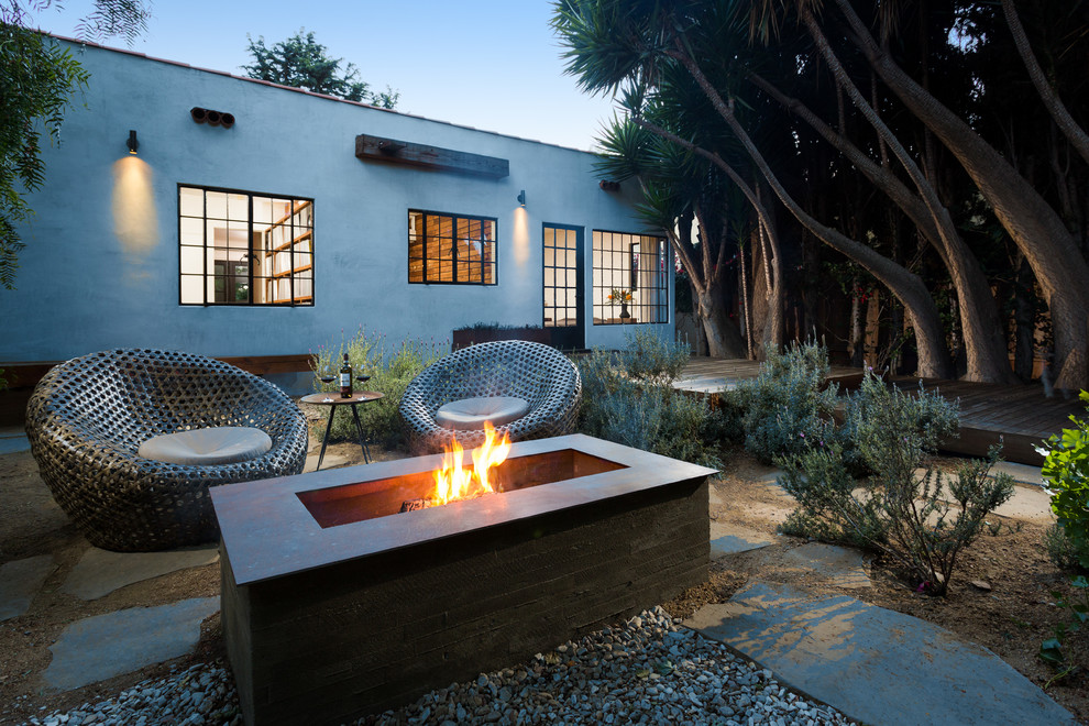 Design ideas for a mid-sized contemporary backyard patio in Los Angeles with a fire feature, natural stone pavers and no cover.