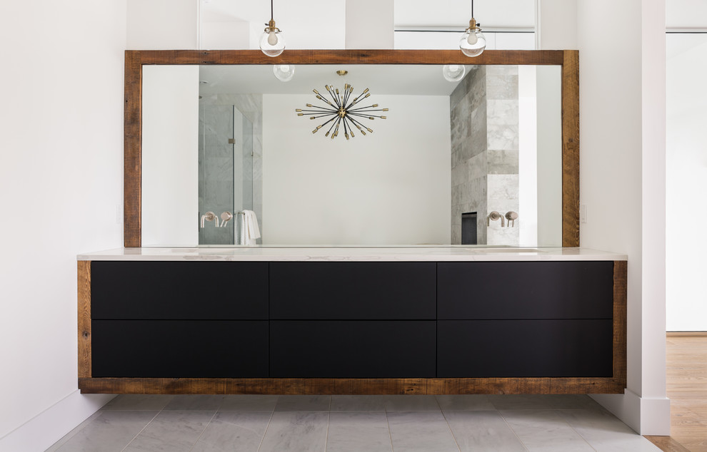 Large modern master bathroom in Calgary with recessed-panel cabinets, black cabinets, a double shower, gray tile, white walls, ceramic floors, a drop-in sink, marble benchtops, white floor and a hinged shower door.