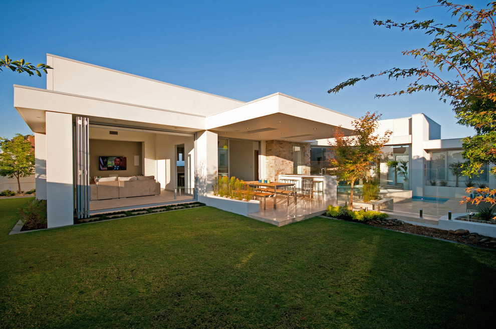Mid-sized contemporary backyard full sun garden in Sydney with natural stone pavers.