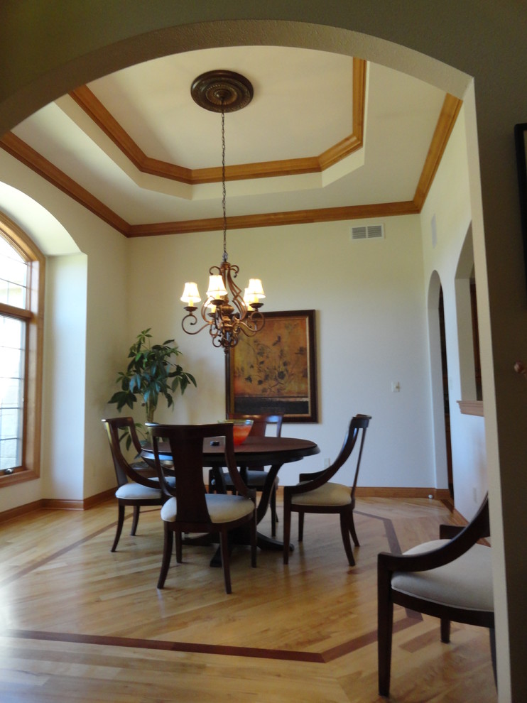 Photo of a mid-sized traditional kitchen/dining combo in Milwaukee with white walls and light hardwood floors.