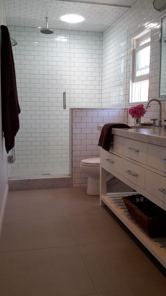 Design ideas for a mid-sized transitional 3/4 bathroom in Los Angeles with flat-panel cabinets, white cabinets, an alcove shower, a two-piece toilet, white tile, subway tile, white walls, concrete floors, an undermount sink and marble benchtops.