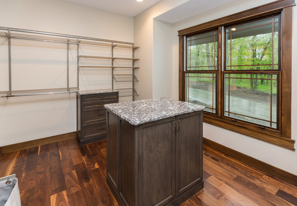 This is an example of a large midcentury gender-neutral walk-in wardrobe in Other with open cabinets, dark wood cabinets and medium hardwood floors.