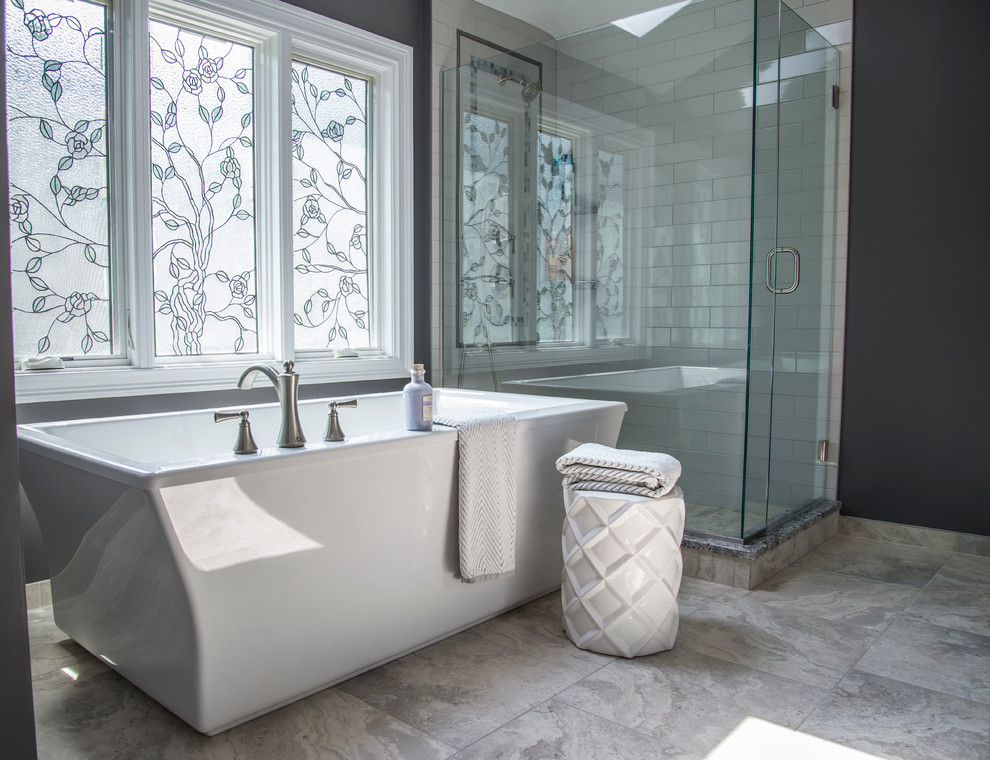 Photo of a mid-sized transitional master bathroom in Chicago with flat-panel cabinets, white cabinets, a freestanding tub, a corner shower, a two-piece toilet, gray tile, subway tile, grey walls, porcelain floors, an undermount sink and granite benchtops.