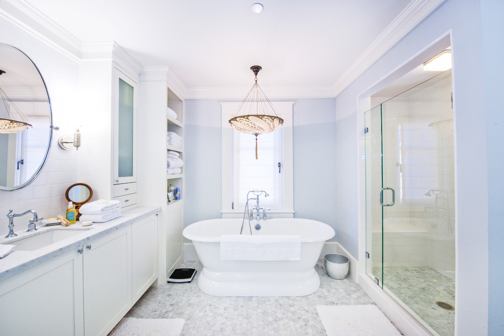 Inspiration for a mid-sized traditional master bathroom in San Francisco with an undermount sink, glass-front cabinets, white cabinets, a freestanding tub, an alcove shower, white walls, a two-piece toilet, marble floors, marble benchtops, white floor and a hinged shower door.