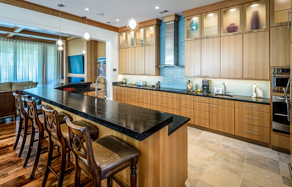 Mid-sized contemporary single-wall open plan kitchen in Charleston with an undermount sink, flat-panel cabinets, light wood cabinets, granite benchtops, blue splashback, glass tile splashback, stainless steel appliances, porcelain floors, with island and beige floor.