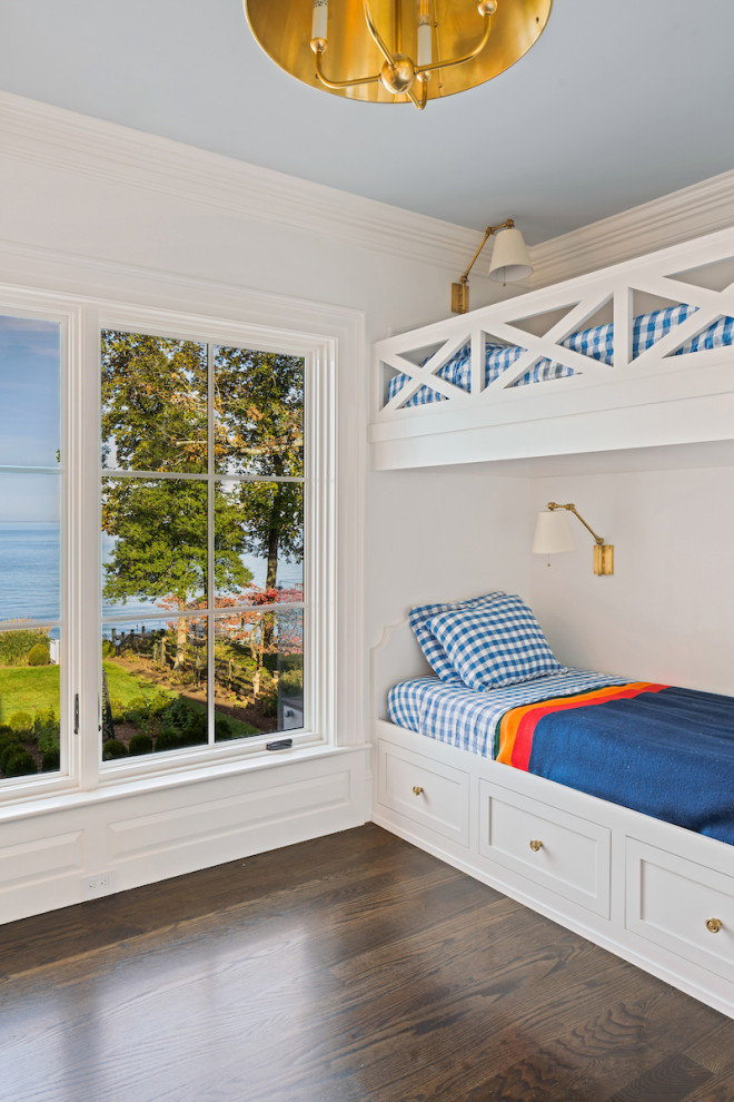 Photo of a small beach style gender neutral kids' bedroom in DC Metro with white walls and dark hardwood flooring.