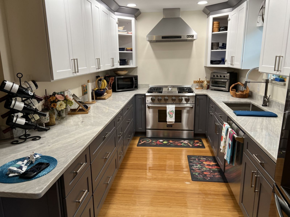 Small galley eat-in kitchen in Jacksonville with an undermount sink, recessed-panel cabinets, grey cabinets, quartzite benchtops, grey splashback, engineered quartz splashback, stainless steel appliances, light hardwood floors, a peninsula, beige floor, white benchtop and coffered.