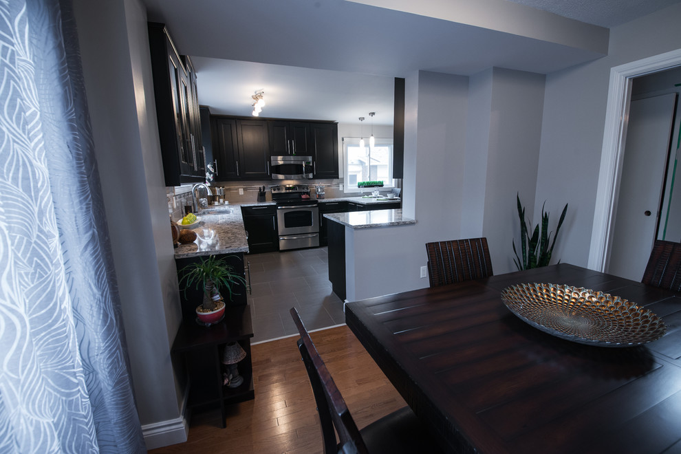 Inspiration for a transitional porcelain tile kitchen/dining room combo remodel in Ottawa with an undermount sink, recessed-panel cabinets, quartz countertops, glass tile backsplash and stainless steel appliances