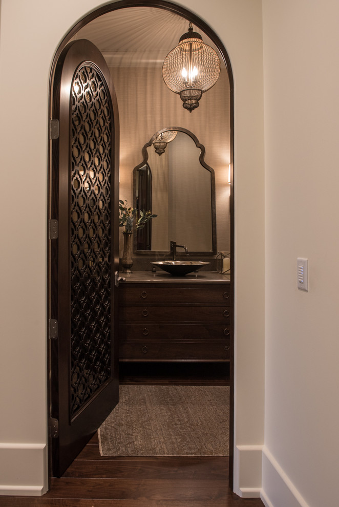 Photo of a mediterranean bathroom in Vancouver with a vessel sink, dark wood cabinets and medium hardwood floors.