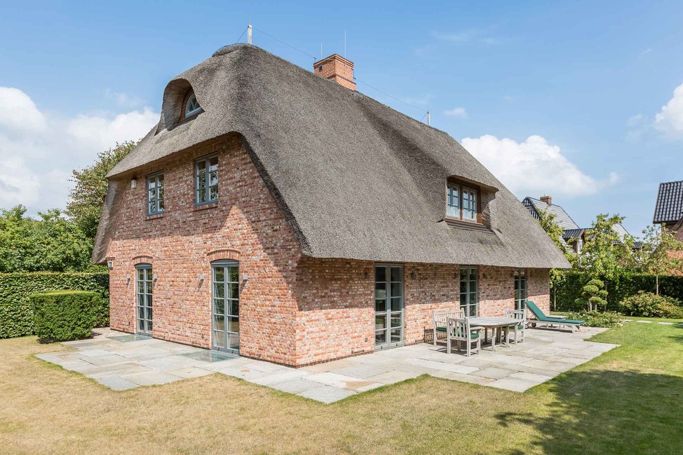 Großes, Dreistöckiges Landhaus Einfamilienhaus mit Backsteinfassade, roter Fassadenfarbe und Halbwalmdach in Sonstige