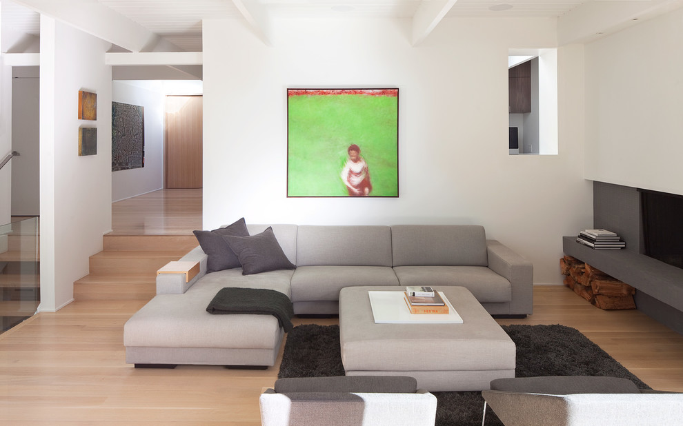 This is an example of a modern living room in Vancouver with white walls and light hardwood floors.