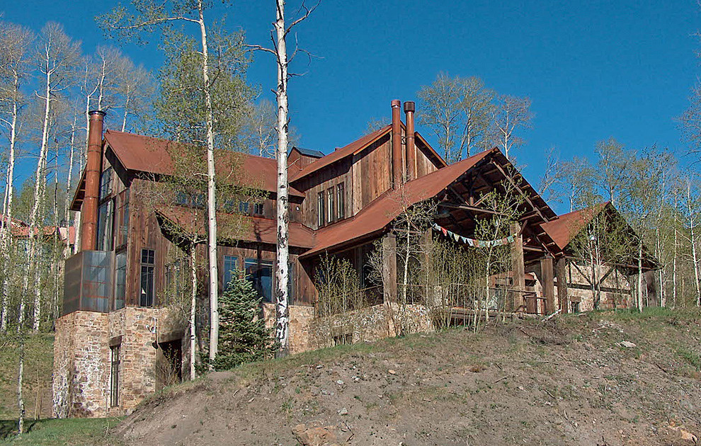 This is an example of a large country three-storey brown house exterior in Denver with wood siding, a gable roof and a metal roof.