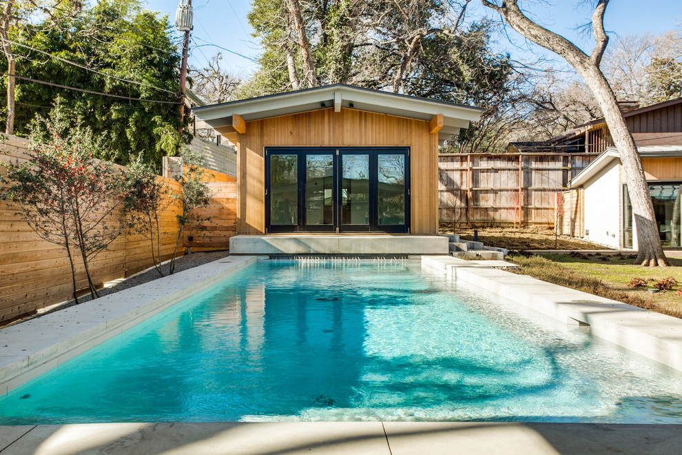 Design ideas for a mid-sized contemporary backyard rectangular lap pool in Dallas with a pool house and concrete slab.