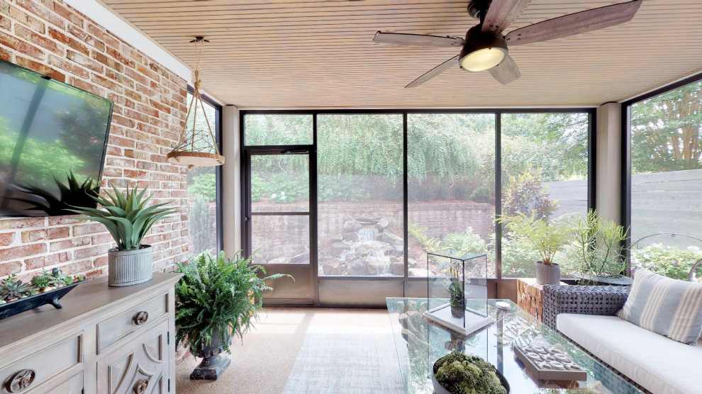 This is an example of a small eclectic sunroom with concrete floors, a standard ceiling and brown floor.
