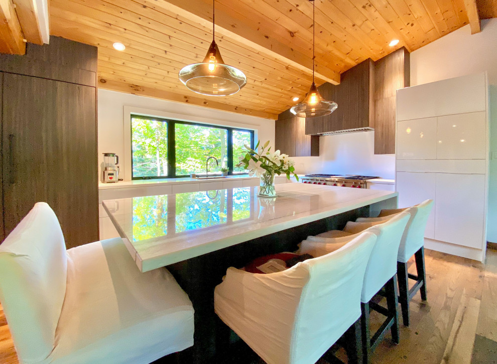 Exemple d'une grande cuisine ouverte moderne en L et bois foncé avec un placard à porte plane, un plan de travail en quartz modifié, une crédence blanche, une crédence en quartz modifié, un sol en bois brun, îlot et un plan de travail blanc.