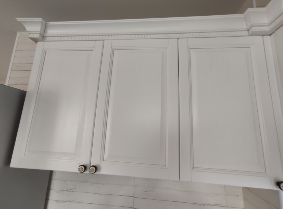 Inspiration pour une cuisine traditionnelle avec un placard avec porte à panneau surélevé et des portes de placard blanches.