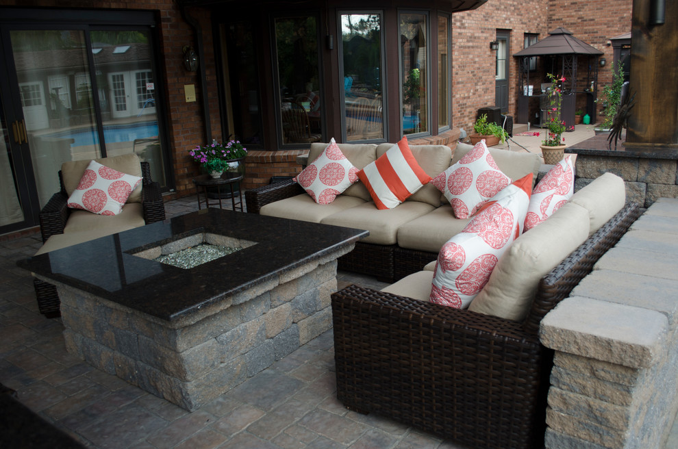 Large beach style backyard concrete paver patio photo in New York with a fire pit and a roof extension