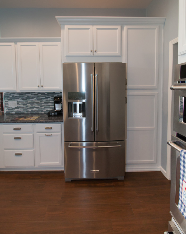 Inspiration for a mid-sized transitional u-shaped porcelain tile and brown floor open concept kitchen remodel with an undermount sink, recessed-panel cabinets, white cabinets, quartz countertops, blue backsplash, mosaic tile backsplash, stainless steel appliances and blue countertops