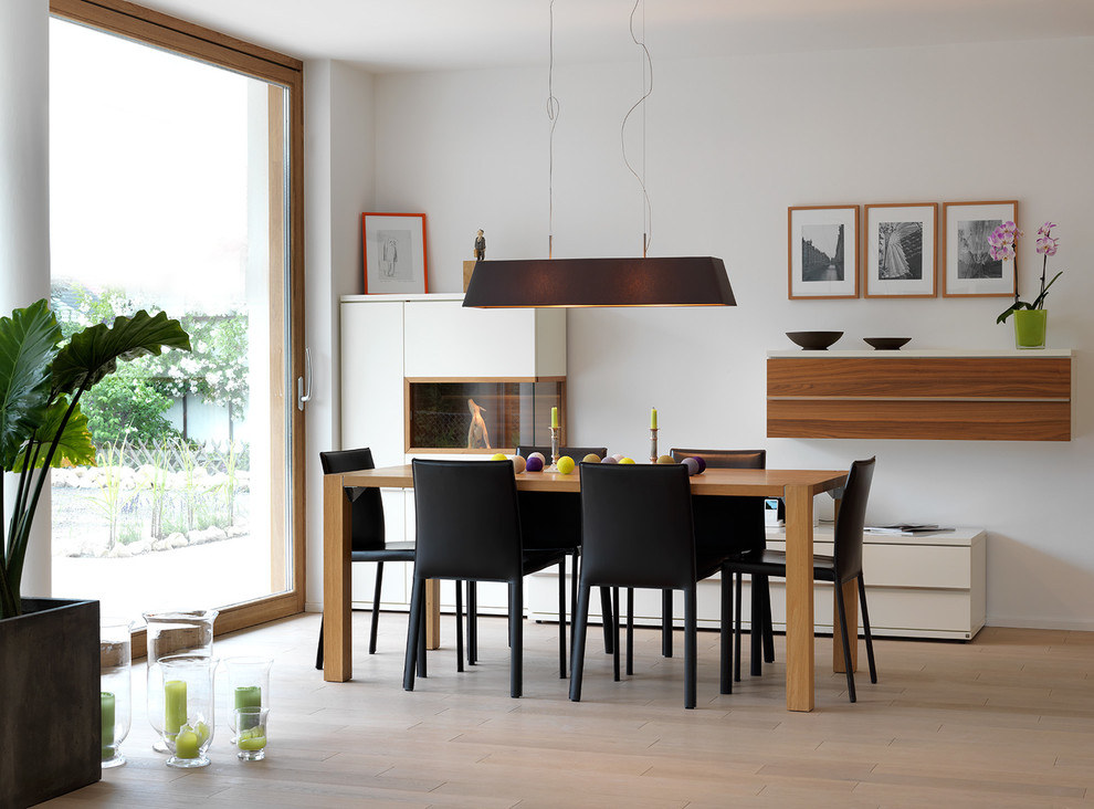 This is an example of a mid-sized contemporary dining room in Nuremberg with white walls and light hardwood floors.
