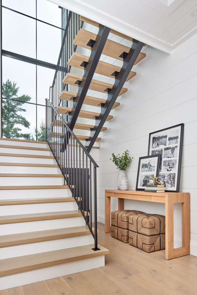 Example of a transitional wooden u-shaped metal railing and shiplap wall staircase design in Toronto with painted risers