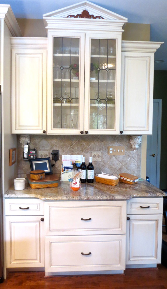 Enclosed kitchen - large traditional u-shaped medium tone wood floor enclosed kitchen idea with raised-panel cabinets, white cabinets, granite countertops, black backsplash and yellow walls
