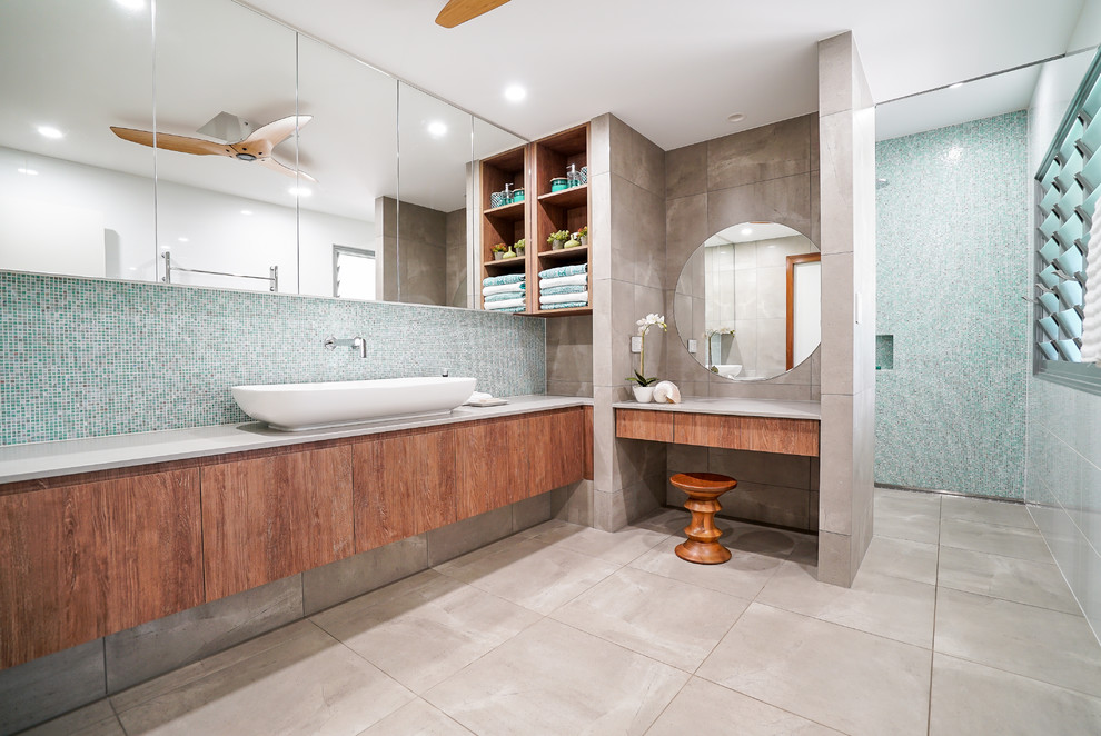 Design ideas for a beach style bathroom in Darwin with flat-panel cabinets, medium wood cabinets, blue tile, multi-coloured walls, a vessel sink and grey floor.