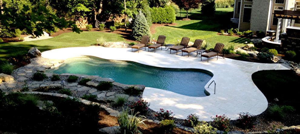 Example of a large transitional backyard custom-shaped and stamped concrete aboveground pool design in New York