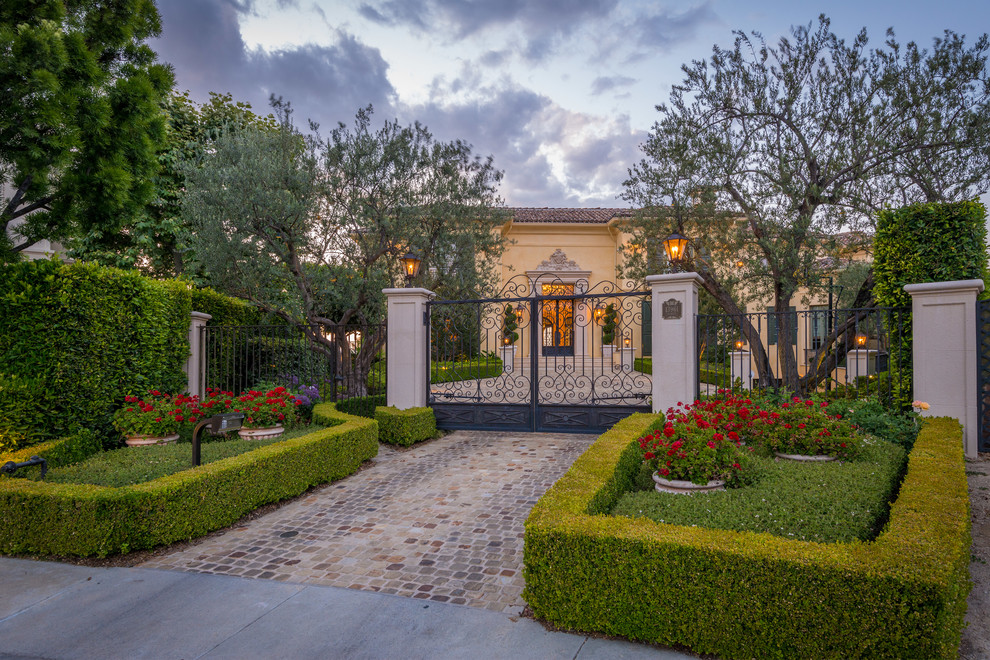 Photo of a mediterranean front yard partial sun driveway in Los Angeles with concrete pavers.